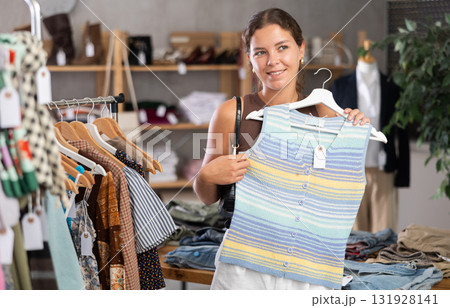 Young woman choosing lazy clothes in boutique Young woman choosing lazy clothes in boutique 131928141