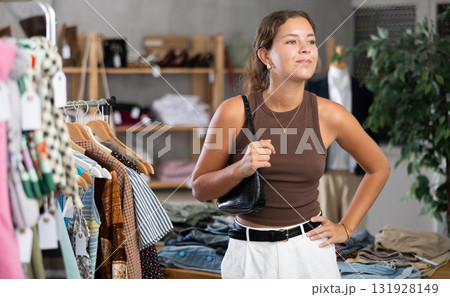 Girl is intently examining sales area of womens clothing store and looking for something Girl is intently examining sales area of womens clothing store and looking for something 131928149