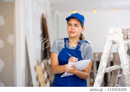 Worried woman builder inspecting construction site Worried woman builder inspecting construction site 131928200