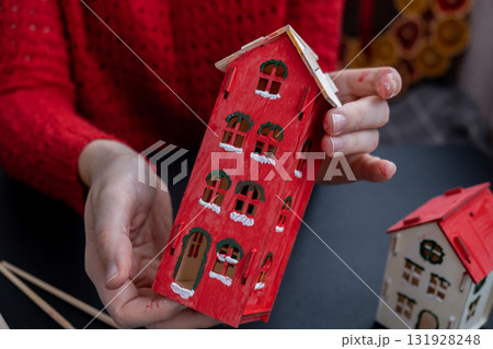Process of preparing for Christmas and New Year eve. 3D craft wooden houses DIY. Responsible ecological zero waste handmade decoration. Children hobby activity Process of preparing for Christmas and New Year eve. 3D craft wooden houses DIY. Responsible ecological zero waste handmade decoration. Children hobby activity 131928248