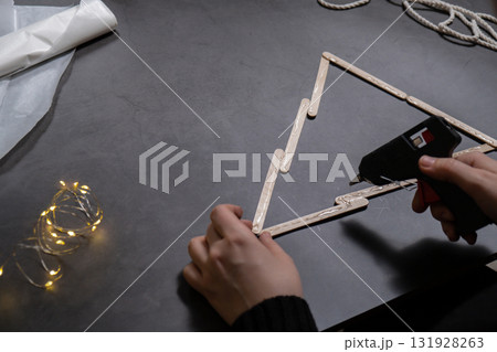 Christmas tree ice cream sticks handmade Storytelling creating craft Christmas holiday decoration. Tactile hand-on activity. Master class progress of creative me-made gifts. Seasonal domestic life 131928263