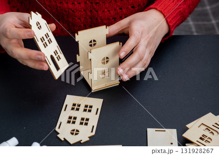 Process of preparing for Christmas and New Year eve. 3D craft wooden houses DIY. Responsible ecological zero waste handmade decoration. Children hobby activity Process of preparing for Christmas and New Year eve. 3D craft wooden houses DIY. Responsible ecological zero waste handmade decoration. Children hobby activity 131928267
