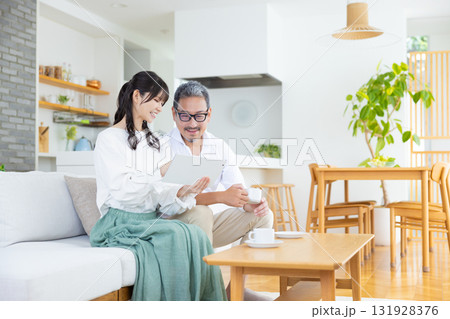 パソコンを見ながら談笑するミドル夫婦 131928376