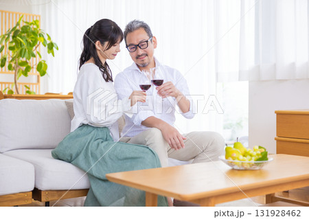 ソファーに座りワインを飲むミドル夫婦 131928462