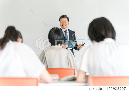 塾・学童で勉強・学校で授業・夏期講習をする男性教師と小学生,中学生の子供（教育） 131928997