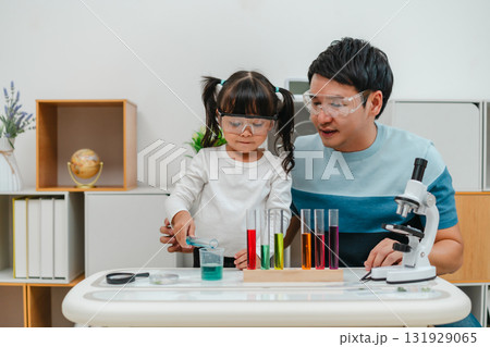 father and toddler girl scientist making chemical test with test tube and beaker. learning science father and toddler girl scientist making chemical test with test tube and beaker. learning science 131929065