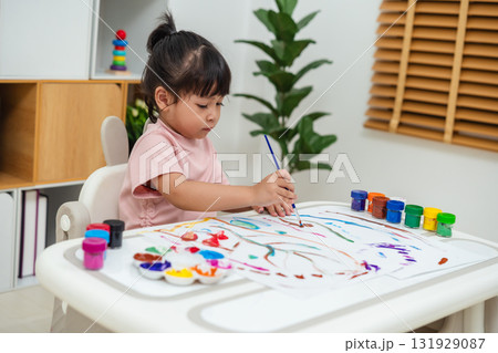 happy toddler girl painting watercolor in paper at home 131929087