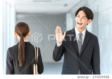 オフィスの廊下を歩くスーツ姿のビジネスマン（出勤,出社,挨拶） 131929388