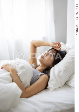 ベッドで痛そうな表情を浮かべる若い女性 ベッドで痛そうな表情を浮かべる若い女性 131929514