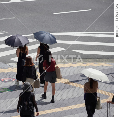 昼の都市の交差点の横断歩道で信号待ちの女性たちの姿 昼の都市の交差点の横断歩道で信号待ちの女性たちの姿 131931123