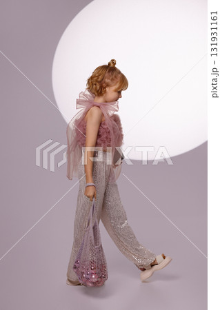 Smiling girl holding Christmas gift and ornaments bag on light background 131931161