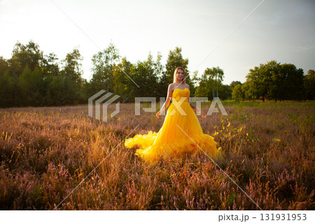 A Stunning Woman Dressed in a Beautiful Yellow Dress Standing Gracefully in a Serene Meadow A Stunning Woman Dressed in a Beautiful Yellow Dress Standing Gracefully in a Serene Meadow 131931953
