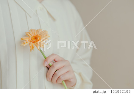 一輪のガーベラの花を持つ女性の手元 一輪のガーベラの花を持つ女性の手元 131932193