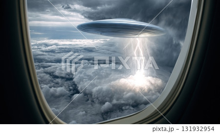 UFO sighting above stormy clouds during flight, a captivating view from an airplane window 131932954
