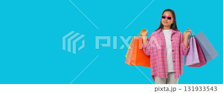 Young woman shops joyfully with colorful bags Young woman shops joyfully with colorful bags 131933543