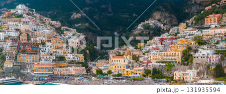 View of Positano on the Amalfi Coast, featuring colorful cliffside buildings, the Church of Santa Maria Assunta, a lively beach, and green cliffs. View of Positano on the Amalfi Coast, featuring colorful cliffside buildings, the Church of Santa Maria Assunta, a lively beach, and green cliffs. 131935594