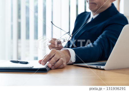 書類に手を伸ばす中高年ビジネスマン 131936291