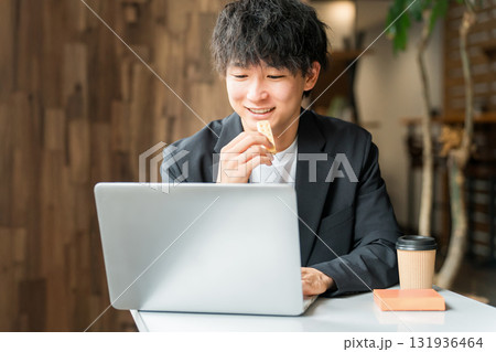カフェで軽食を取りながらパソコンを使って仕事するビジネスマン・男性 カフェで軽食を取りながらパソコンを使って仕事するビジネスマン・男性 131936464