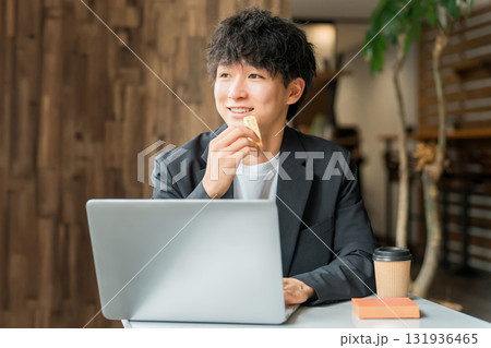 カフェで軽食を取りながらパソコンを使って仕事するビジネスマン・男性 カフェで軽食を取りながらパソコンを使って仕事するビジネスマン・男性 131936465