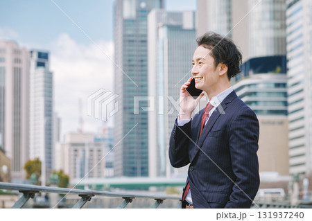 屋外で電話をするビジネスマン 屋外で電話をするビジネスマン 131937240