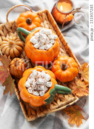 Warming pumpkin mugs filled with hot chocolate and marshmallows Warming pumpkin mugs filled with hot chocolate and marshmallows 131937285