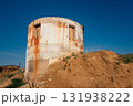 old round building on hill with rusted exterior and clear blue sky in background. closeup. 131938222