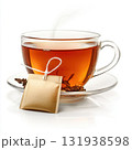 Freshly brewed herbal tea in a glass cup with steam rising and a tea bag resting on a saucer 131938598