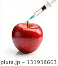 Red apple being injected with liquid from a syringe in a sterile environment 131938603