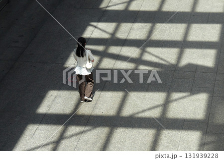 ハイアングルで見た夏の都市の街で歩く一人の女性の姿 131939228