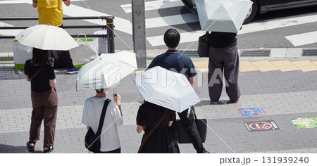 夏の昼の都市の交差点の横断歩道で信号待ちの人々の姿 夏の昼の都市の交差点の横断歩道で信号待ちの人々の姿 131939240