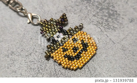 Handcrafted pumpkin-shaped keychain made of orange seed beads and glass beads Handcrafted pumpkin-shaped keychain made of orange seed beads and glass beads 131939788