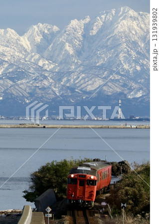 立山連峰と氷見線を走るキハ40 131939802