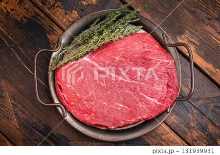 Premium raw rump or top sirloin beef steak on a tray, ready to be seasoned and grilled to perfection. wooden background. top view Premium raw rump or top sirloin beef steak on a tray, ready to be seasoned and grilled to perfection. wooden background. top view 131939931