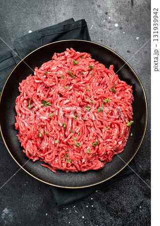 Lamb Mutton ground mince raw meat, forcemeat on a black plate, top view. Lamb Mutton ground mince raw meat, forcemeat on a black plate, top view. 131939942