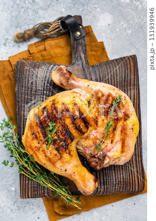 Roast chicken legs with Thigh on wooden cutting board, grilled poultry meat on gray background, top view 131939946