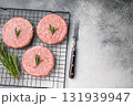 Close up of a juicy raw meat patty cutlet, ideal for crafting mouthwatering sandwiches and savory dishes. white background. top view 131939947