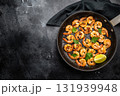 Fried Shrimps Prawns with garlic and butter in a skillet. Black background. Top view 131939948