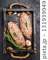 Raw kebabs or kabaps on wooden tray, beautifully arranged and ready to be cooked for a delicious outdoor feast. black background. top view 131939949