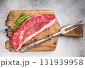 Uncooked striploin steak or strip New York on a wooden cutting board, inviting you to create mouthwatering recipes for any occasion. white background. top view 131939958