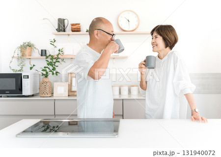 キッチンでホットドリンクを飲む中高年の夫婦 131940072