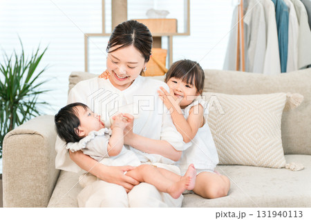ソファーで赤ちゃんを抱っこする母親,ママ(育児,専業主婦) ソファーで赤ちゃんを抱っこする母親,ママ(育児,専業主婦) 131940113