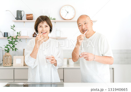 キッチンで歯を磨くシニア夫婦（デンタルケア,口臭ケア） 131940665