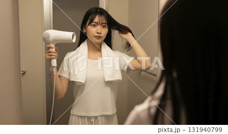 お風呂上がり、部屋着でドライヤーで髪を乾かしている お風呂上がり、部屋着でドライヤーで髪を乾かしている 131940799