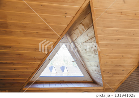 A triangular dormer window on the attic floor, viewed from inside the house 131941028