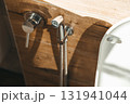 Hygiene bidet shower on wall near toilet in house 131941044