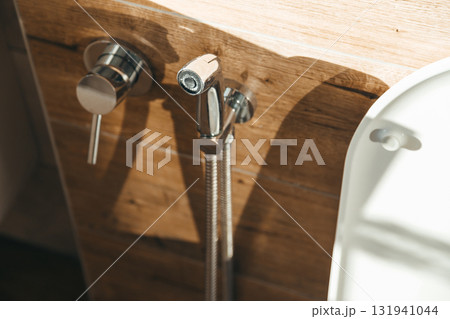 Hygiene bidet shower on wall near toilet in house 131941044