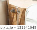 Hygiene bidet shower on wall near toilet in house 131941045
