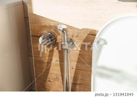 Hygiene bidet shower on wall near toilet in house Hygiene bidet shower on wall near toilet in house 131941045