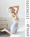 Cheerful attractive woman with a towel wrapped around her head posing in bathroom 131941050