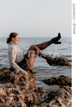 Woman Ocean Rocks Fashion: Coastal photoshoot; stylish model poses on rocks by sea. Woman Ocean Rocks Fashion: Coastal photoshoot; stylish model poses on rocks by sea. 131941075